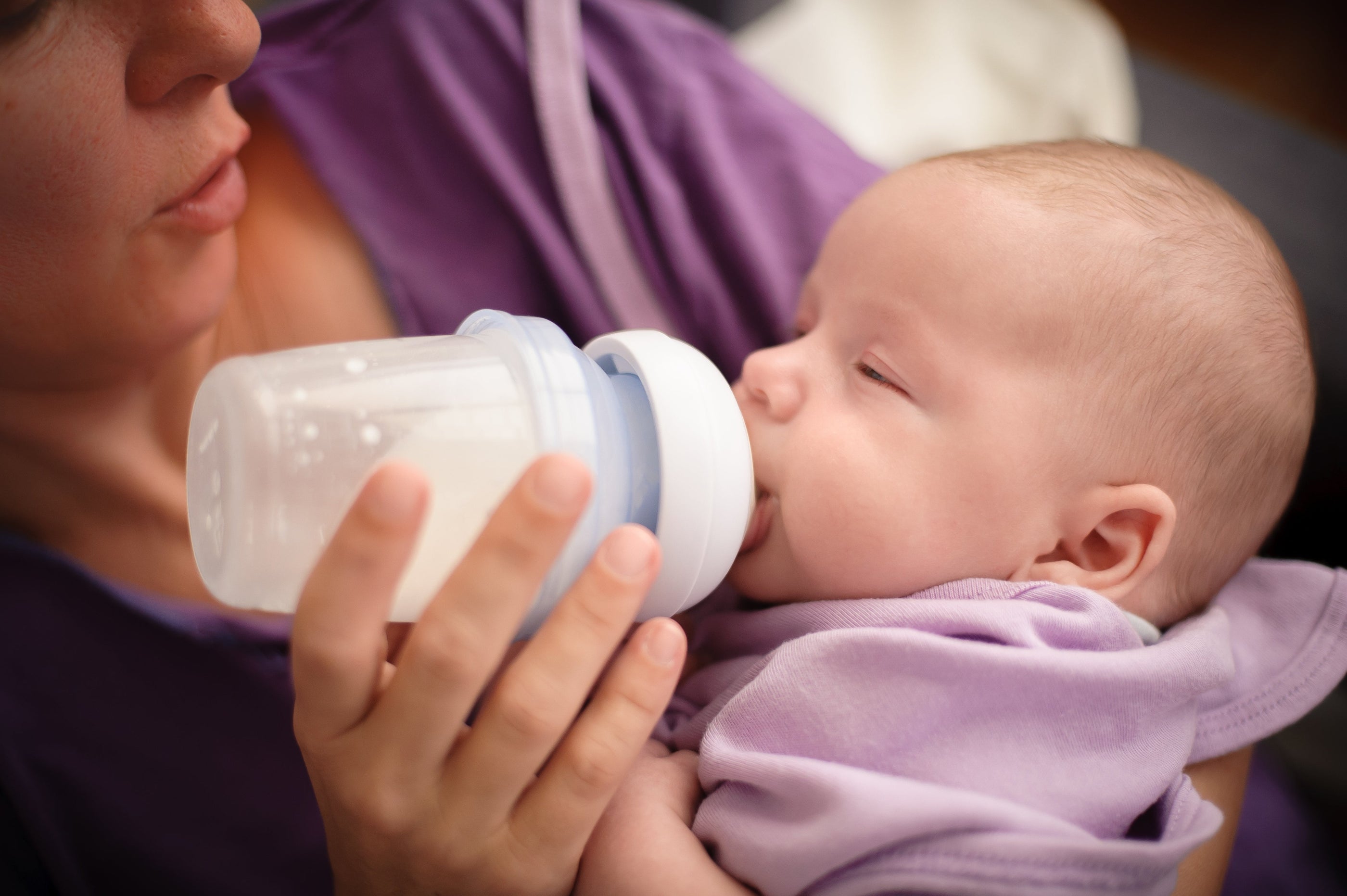 Mom dream feeding baby with bottle