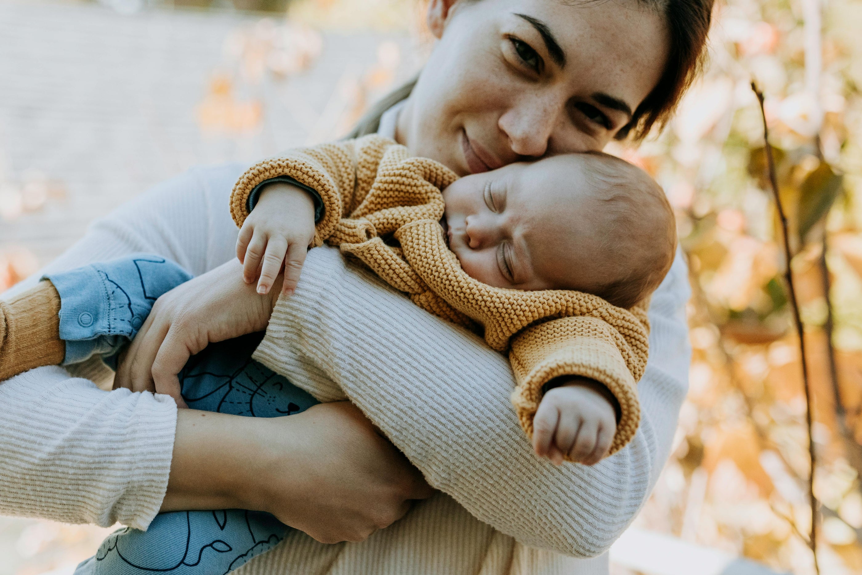 Navigating Pregnancy & Postpartum photo with smiling mom holding baby outside