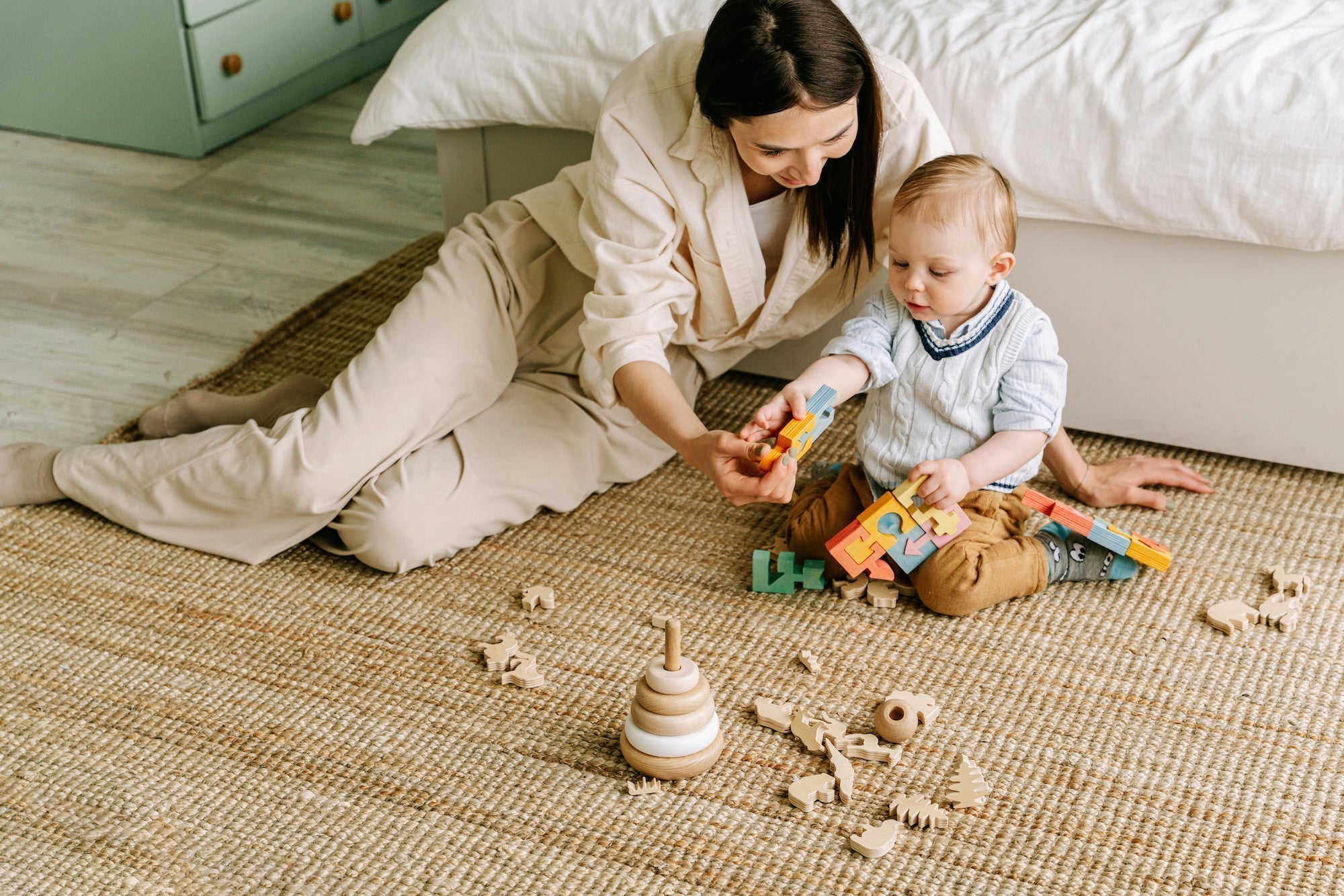 Mother on floor playing blocks and toys with toddler boy