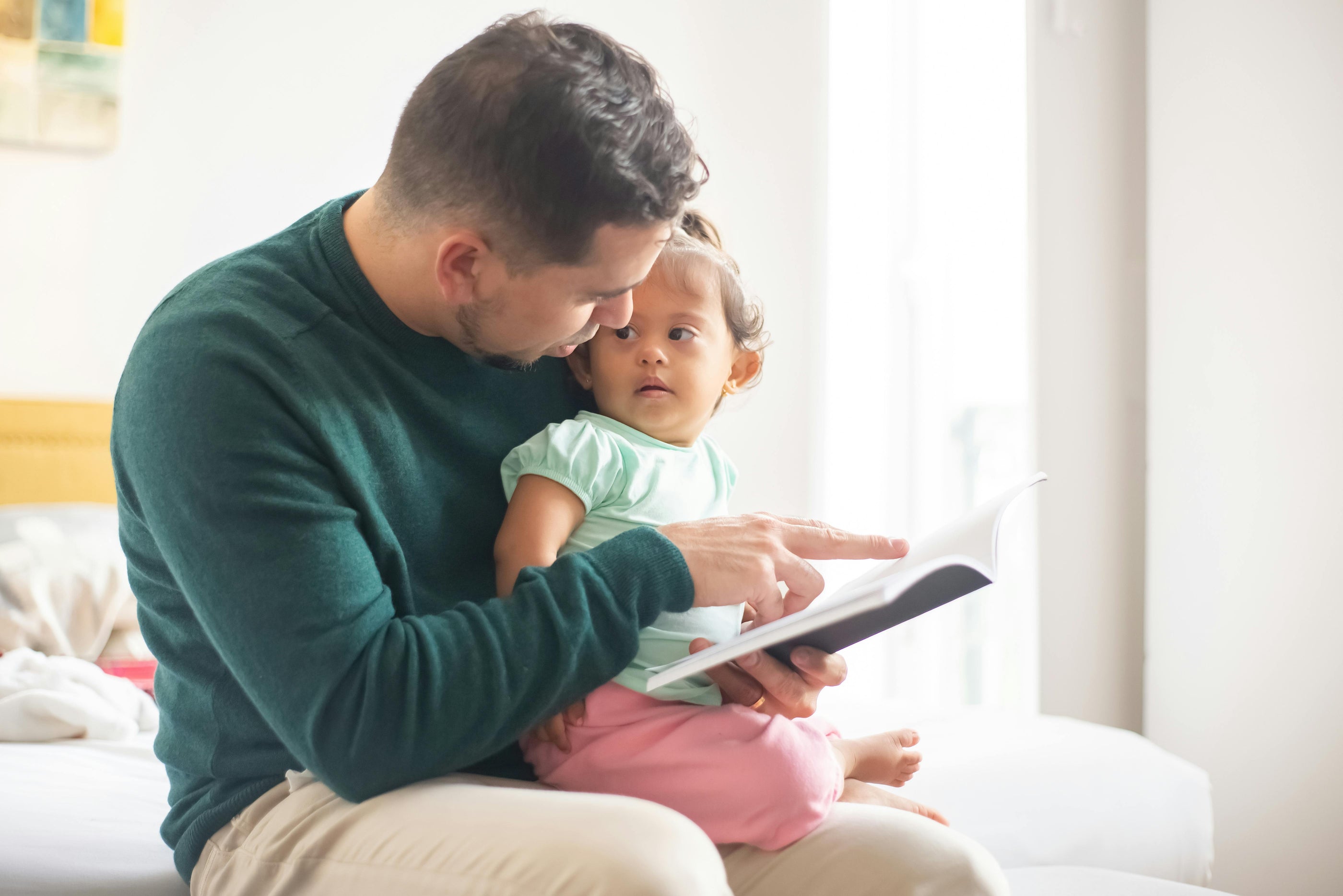 dad reading to baby girl