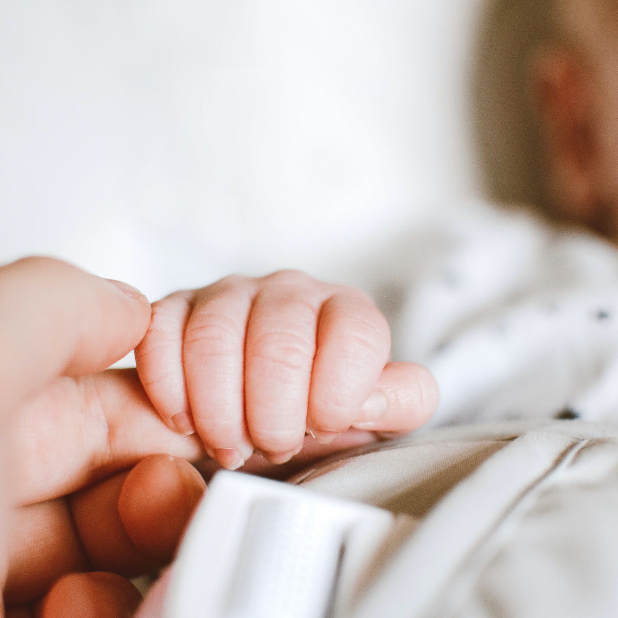 baby holding parent's hand